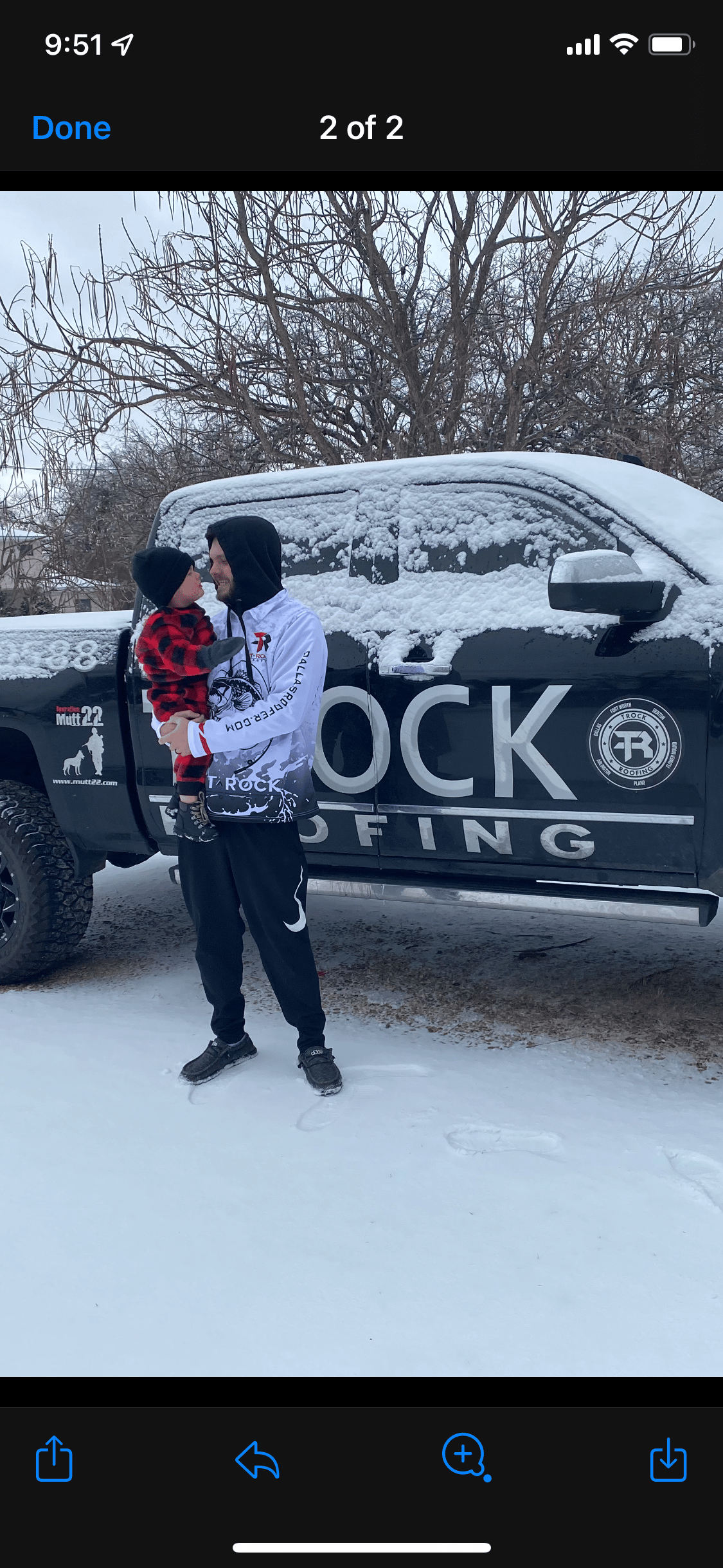 Man and son standing in snow next to a truck