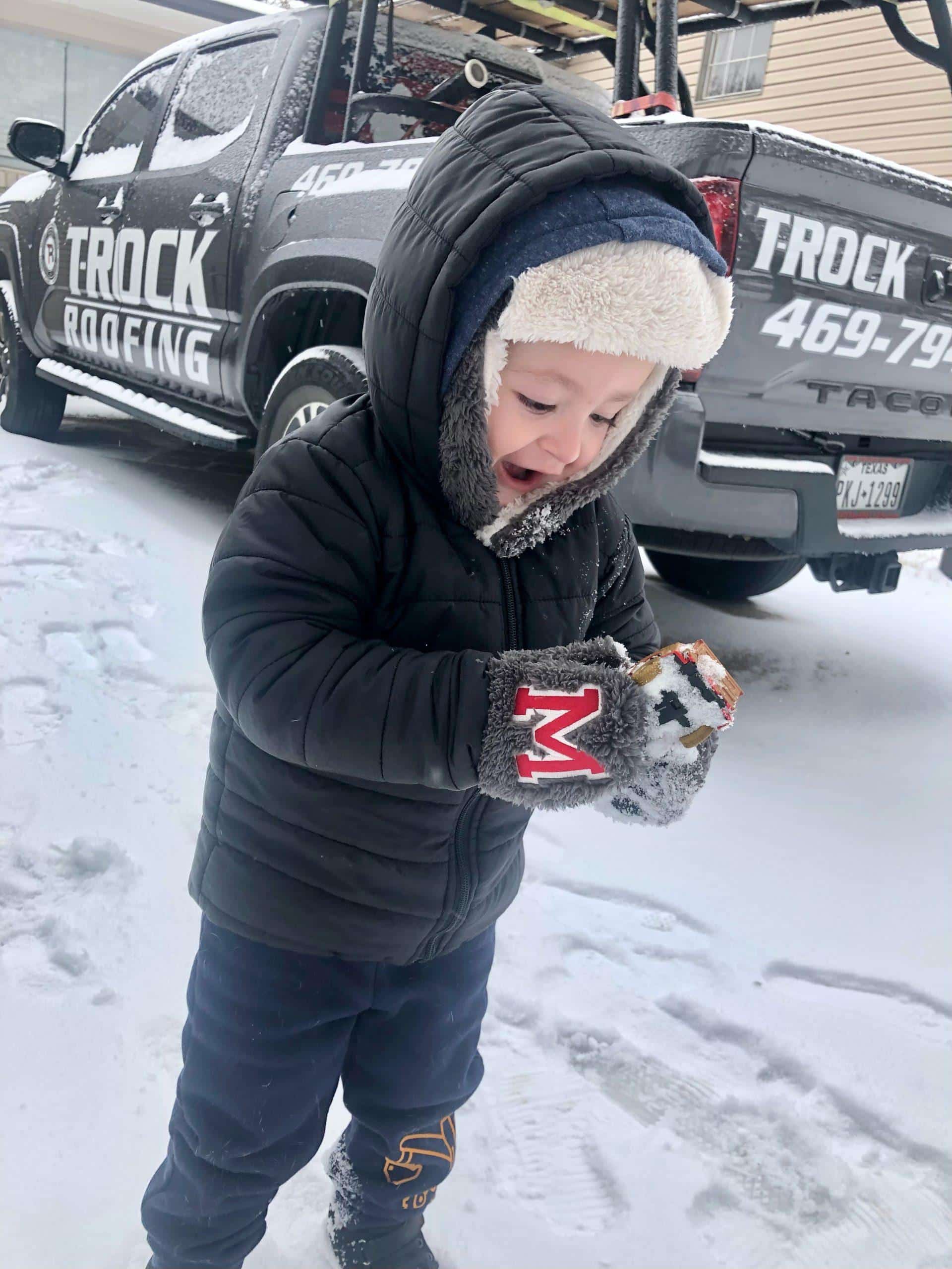 child smiling at snow